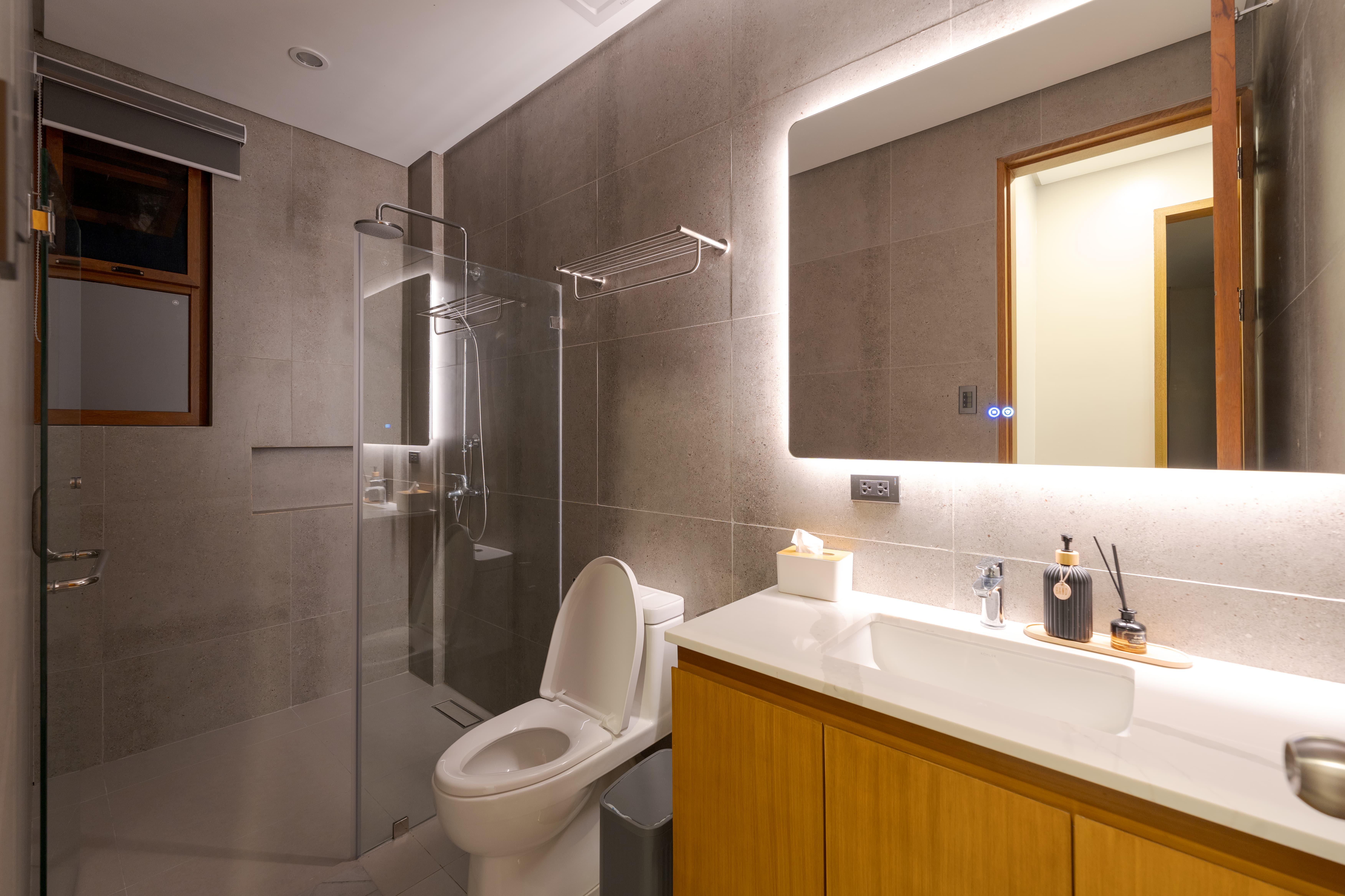 Modern bathroom with backlit mirror and walk-in shower