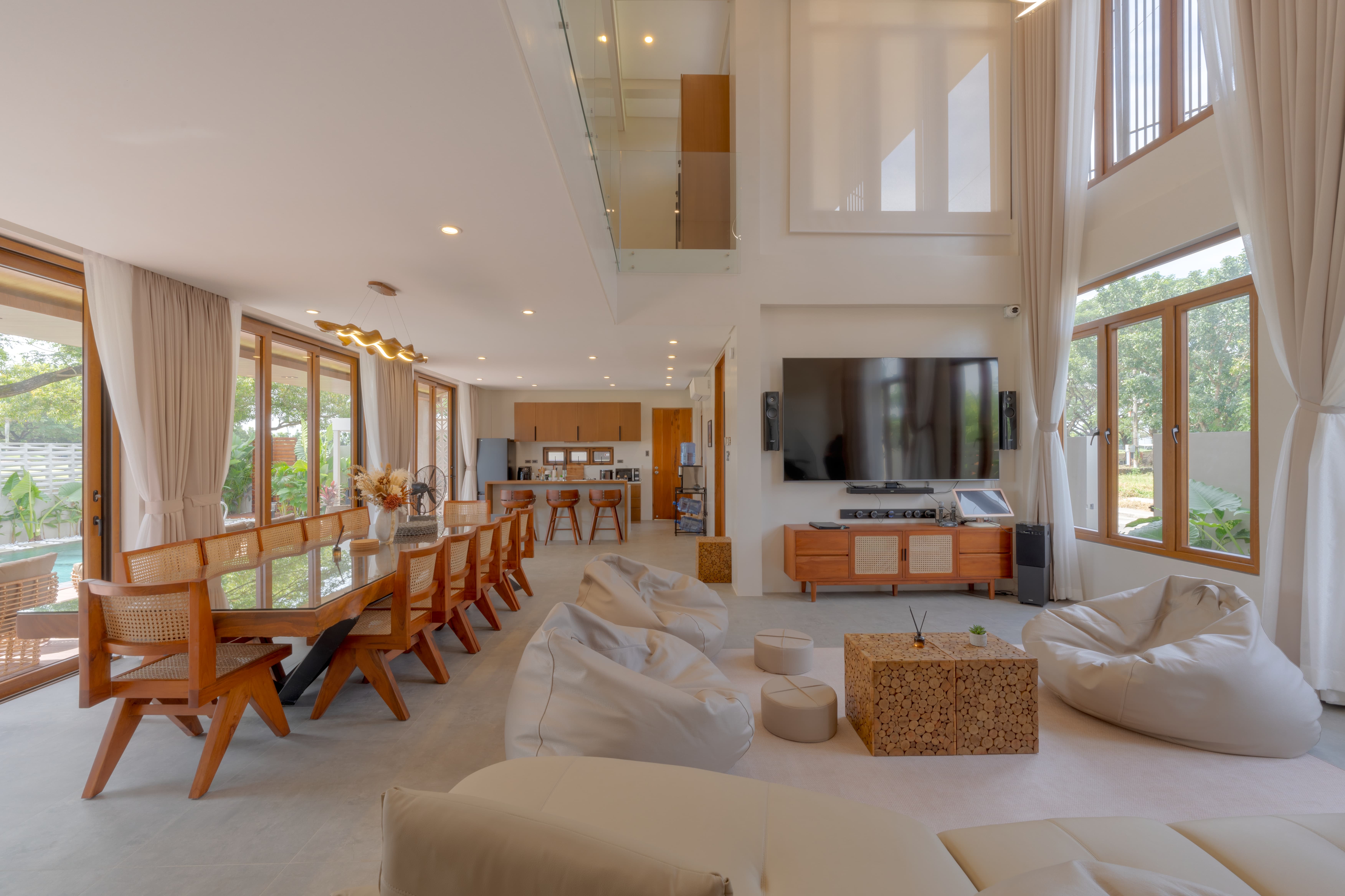 Open-plan living room with double-height ceilings and warm wood detailing